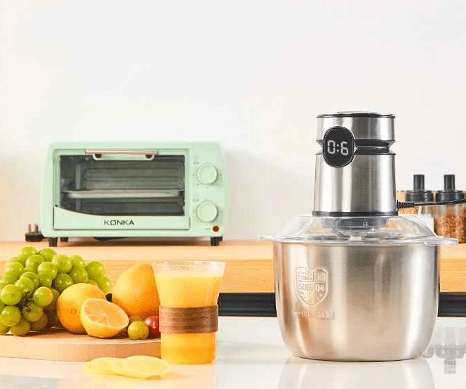 hachoir électrique sur la table de cuisine avec des fruits