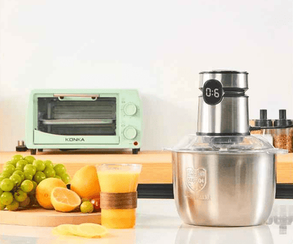 hachoir électrique sur la table de cuisine avec des fruits